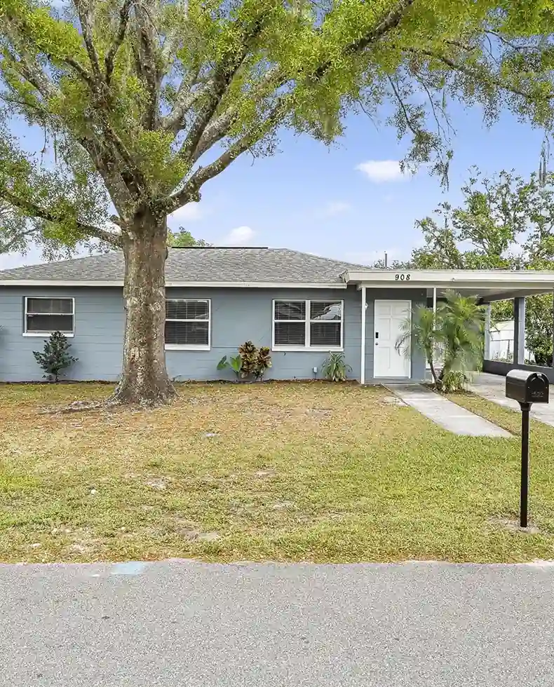 Freshly renovated rental property with a blue exterior and mature tree—part of ArmCoa’s rapid-turn renovation service.