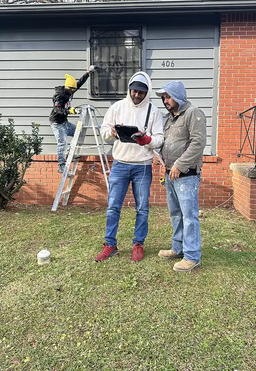 ArmCoa field team reviewing project plans outside a home during a renovation—highlighting hands-on leadership and real-time execution.